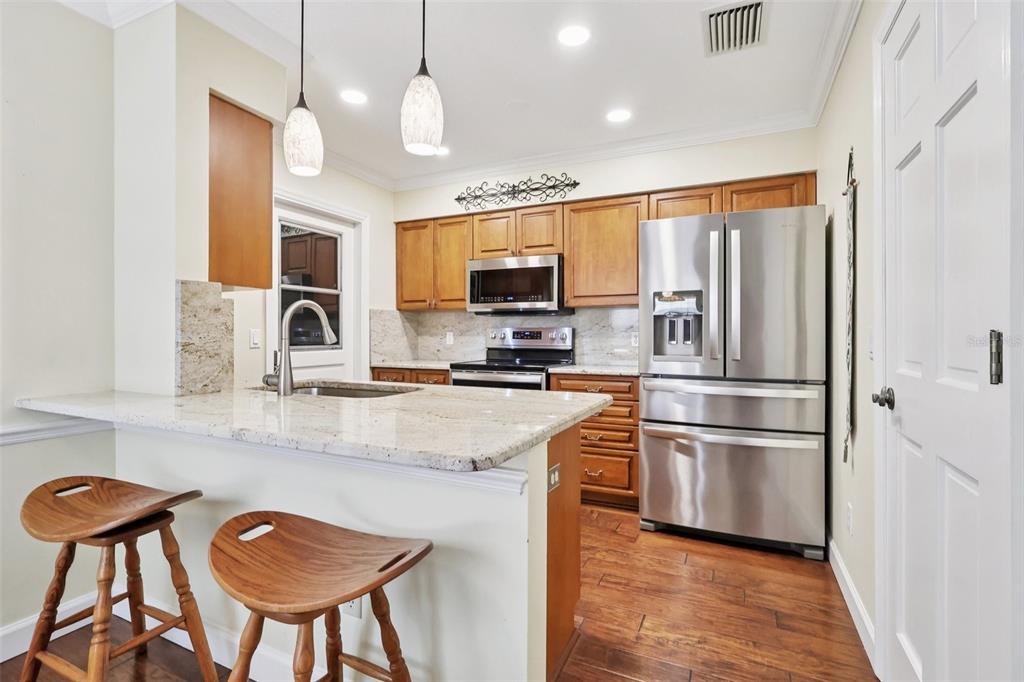 116 Baytree Boulevard Tavares, FL 32778 - Photo 4 of 47 a kitchen with stainless steel appliances granite countertop a sink refrigerator and microwave
