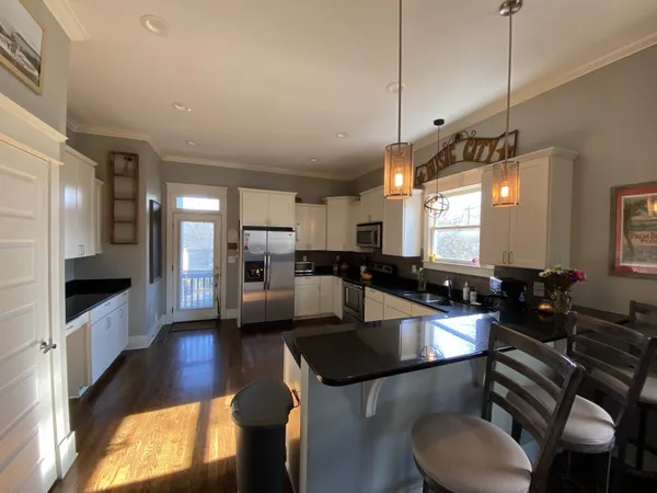 a kitchen with stainless steel appliances granite countertop a sink a stove top oven a counter space and cabinets