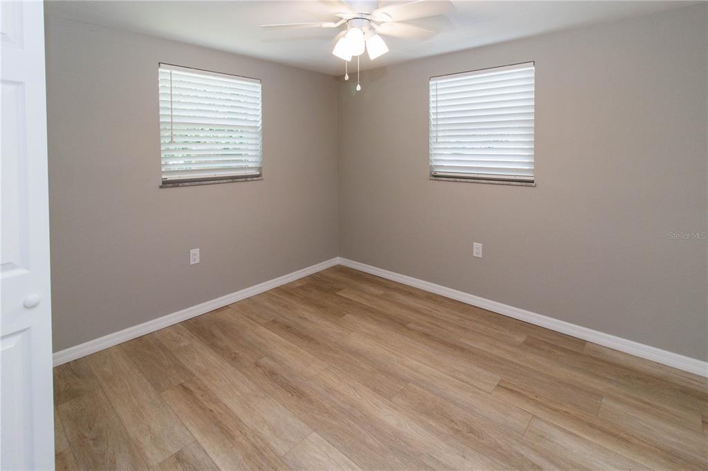 8313 Gulf Way Hudson, FL 34667 - Photo 14 of 27 an empty room with wooden floor and windows