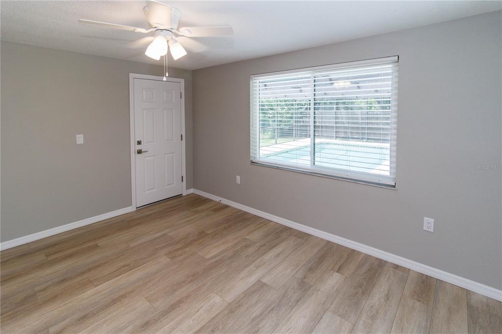 8313 Gulf Way Hudson, FL 34667 - Photo 19 of 27 a view of an empty room with wooden floor and a window