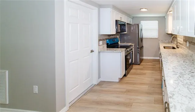 a kitchen with stainless steel appliances granite countertop a refrigerator a stove top oven a sink and dishwasher