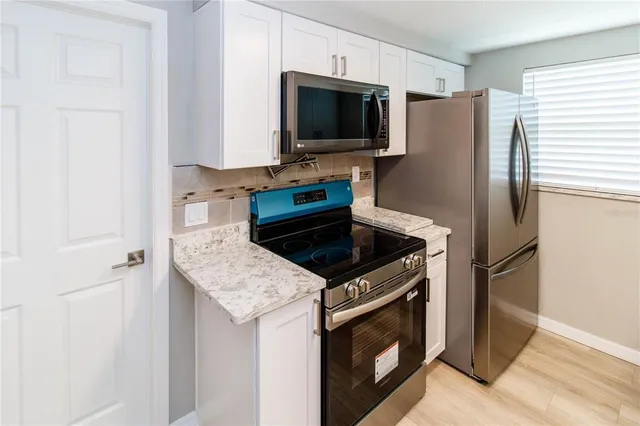 a kitchen with granite countertop a stove and a refrigerator