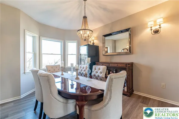 a dining room with furniture a chandelier and wooden floor
