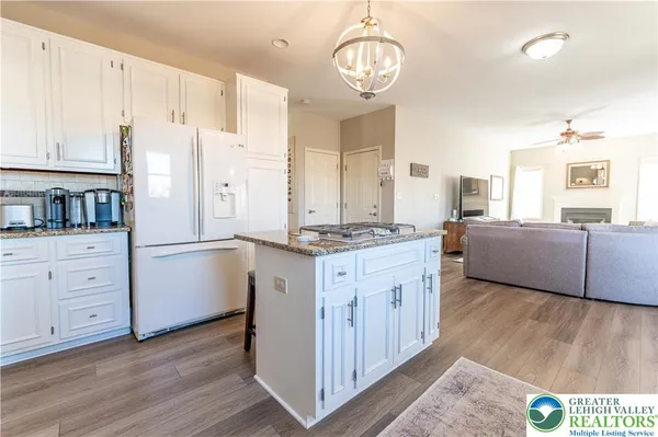 a kitchen with stainless steel appliances granite countertop a stove top oven a sink dishwasher a dining table and chairs with wooden floor