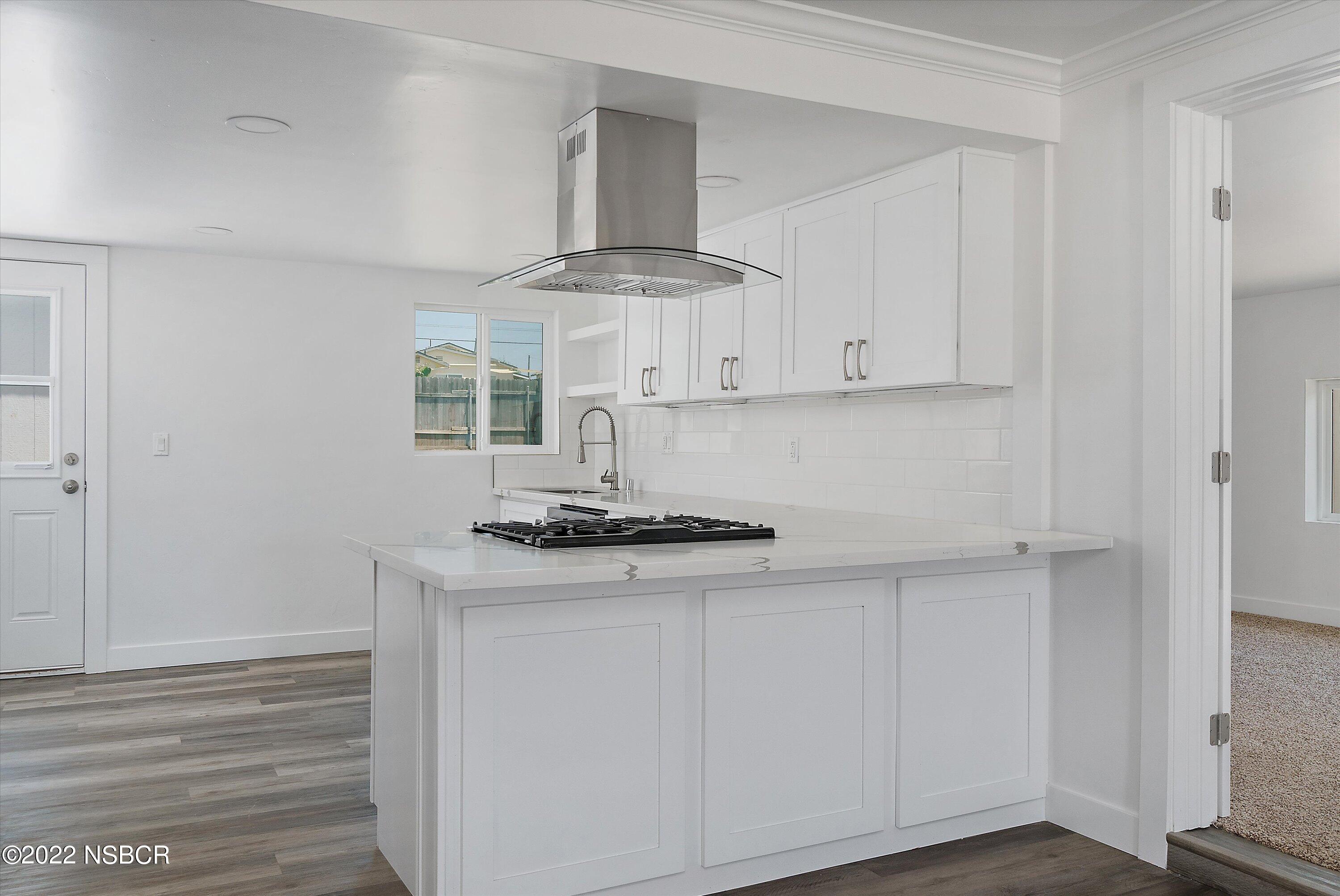 455 Longbranch Avenue Grover Beach, CA 93433 - Photo 11 of 23 a kitchen with stainless steel appliances granite countertop white cabinets and a stove top oven