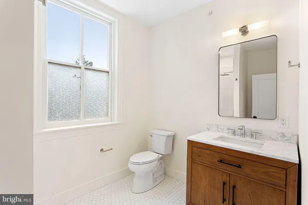 a bathroom with a toilet sink and mirror