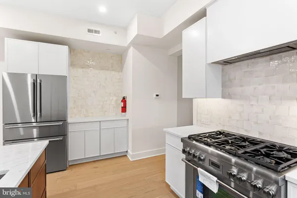 a kitchen with stainless steel appliances granite countertop a refrigerator and a stove