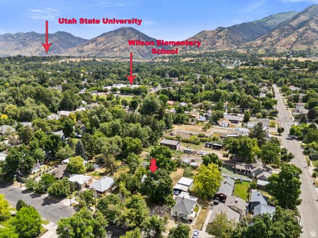 148 South 300 East Logan, UT 84321 - Photo 29 of 29 Aerial perspective showcasing a residential neighborhood with abundant mature trees and mountainous terrain