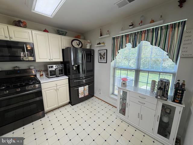 46891 Eaton Terrace, Unit 101 Sterling, VA 20164 - Photo 30 of 41 a kitchen with granite countertop a refrigerator a stove a sink and white cabinets with wooden floor