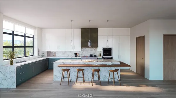 a view of a kitchen with kitchen island a dining table chairs and a window