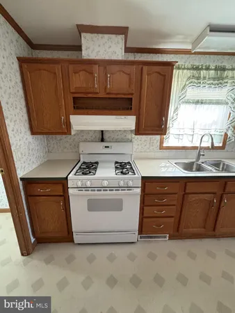 a white stove top oven sitting inside of a kitchen