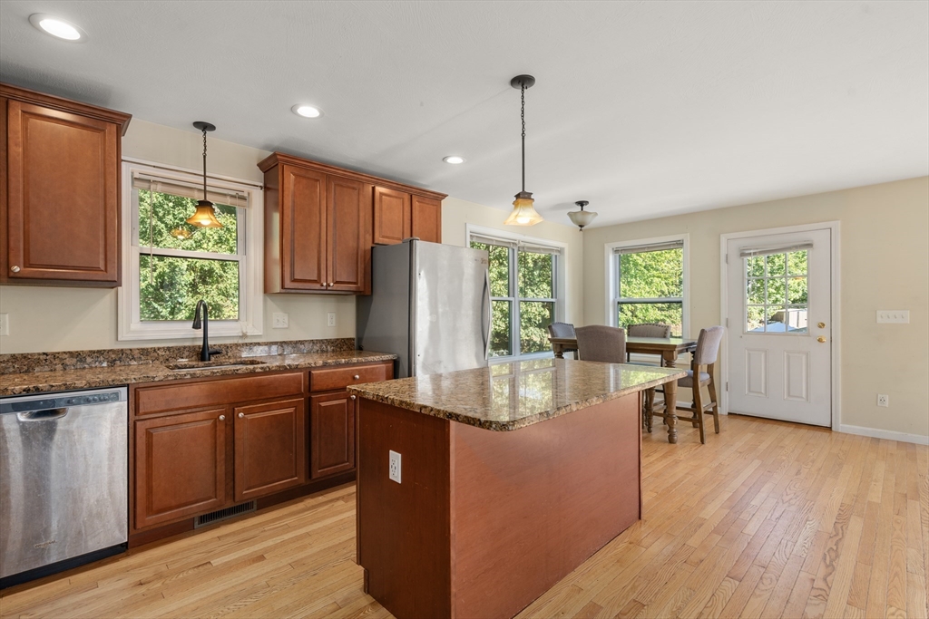 190 Old Road Dracut, MA 01826 - Photo 2 of 36 a kitchen with stainless steel appliances granite countertop wooden floors a stove a sink and white cabinets with wooden floor