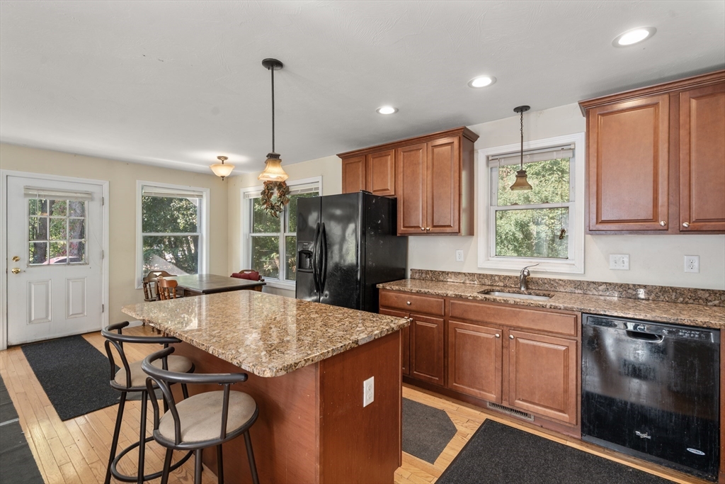 190 Old Road Dracut, MA 01826 - Photo 29 of 36 a kitchen with stainless steel appliances granite countertop a kitchen island hardwood floor sink stove dining table and chairs