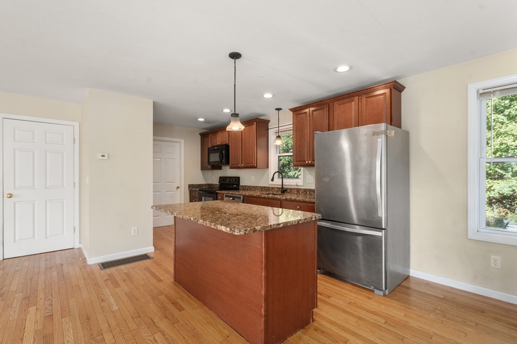 190 Old Road Dracut, MA 01826 - Photo 3 of 36 a kitchen with stainless steel appliances granite countertop a refrigerator a sink a stove and a wooden floors