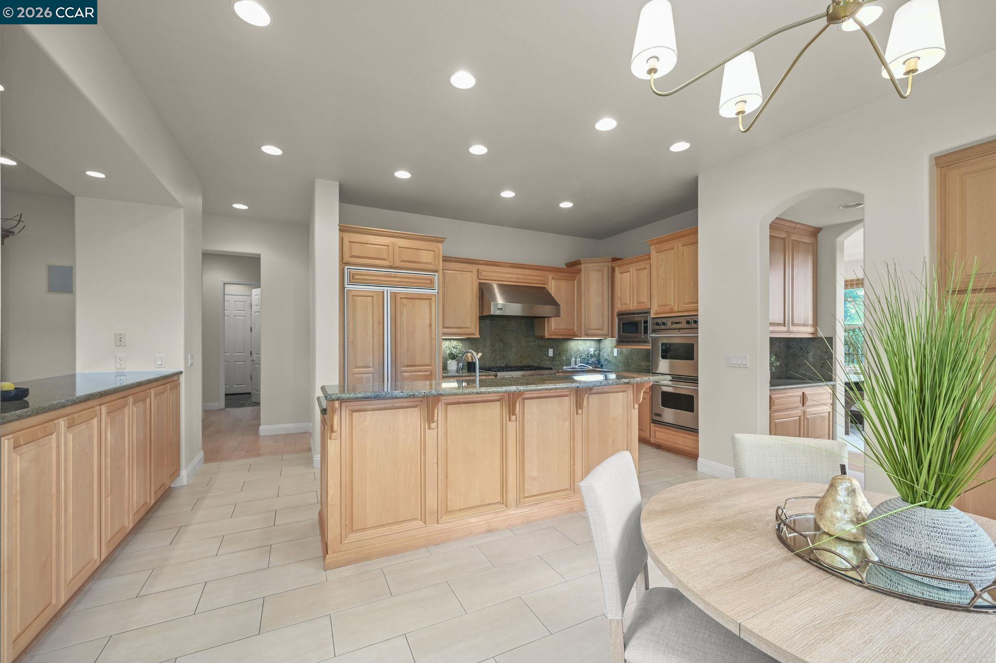 135 Diablo Ranch Court Danville, CA 94506 - Photo 21 of 60 a kitchen with stainless steel appliances kitchen island granite countertop a refrigerator a stove a sink and a dining table