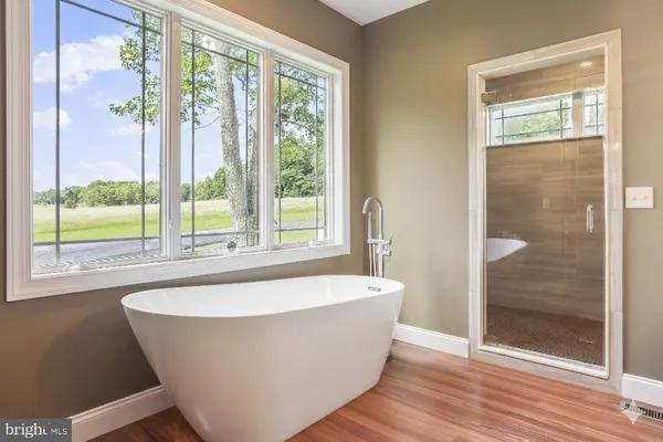 a white bath tub sitting in a bathroom next to a window