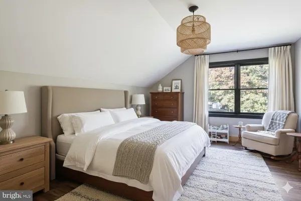 a bedroom with a large bed and a chandelier