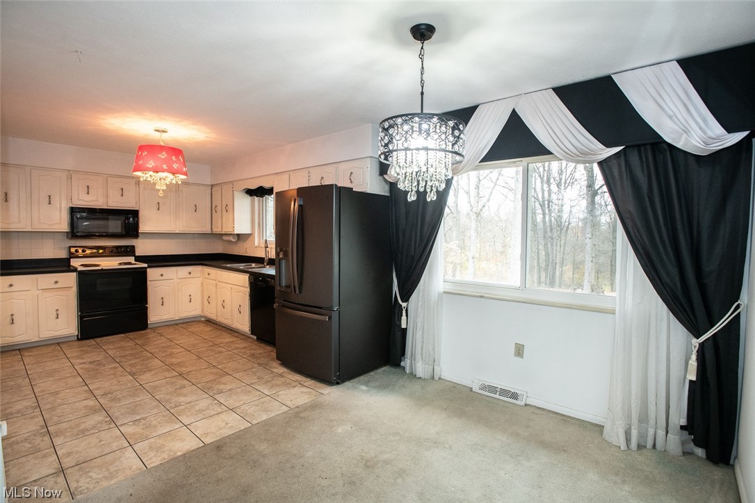 14358 Prospect Road Strongsville, OH 44149 - Photo 4 of 35 Kitchen with hanging light fixtures, sink, light colored carpet, a chandelier, and black appliances