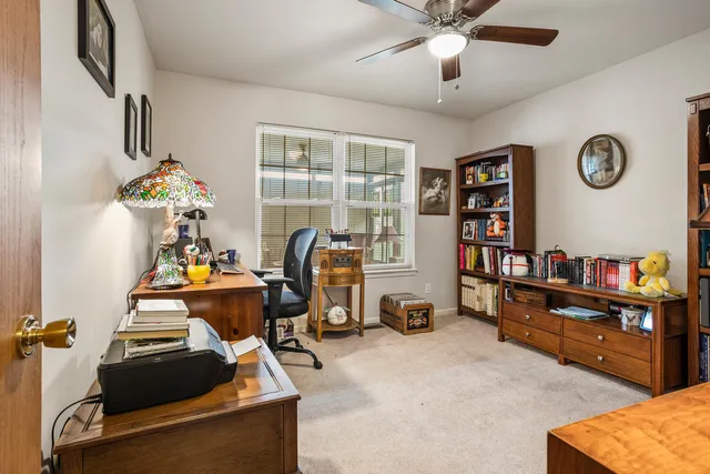 a view of a workspace with furniture and a window