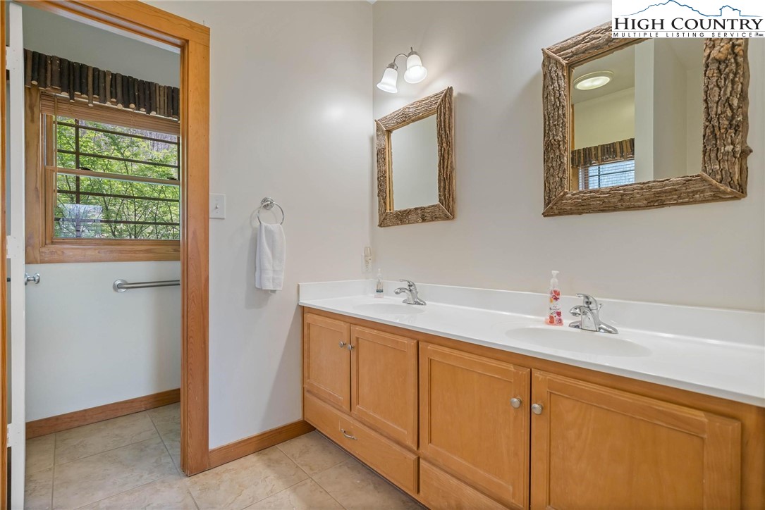 140 Spruce Hollow Road Beech Mountain, NC 28604 - Photo 18 of 50 a bathroom with a double vanity sink and a mirror