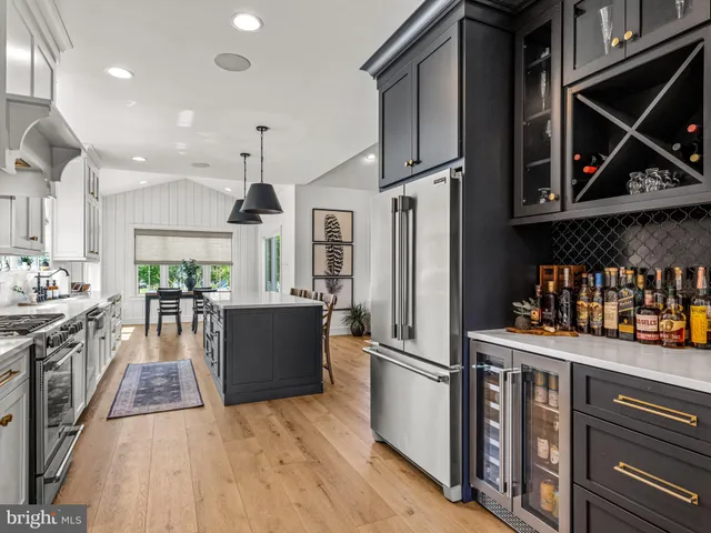 a kitchen with stainless steel appliances granite countertop a refrigerator a stove and a wooden floors