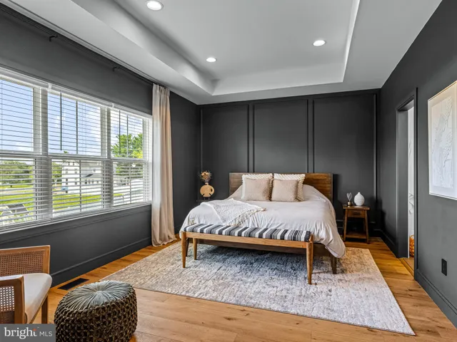a bed sitting in a spacious bedroom next to a window
