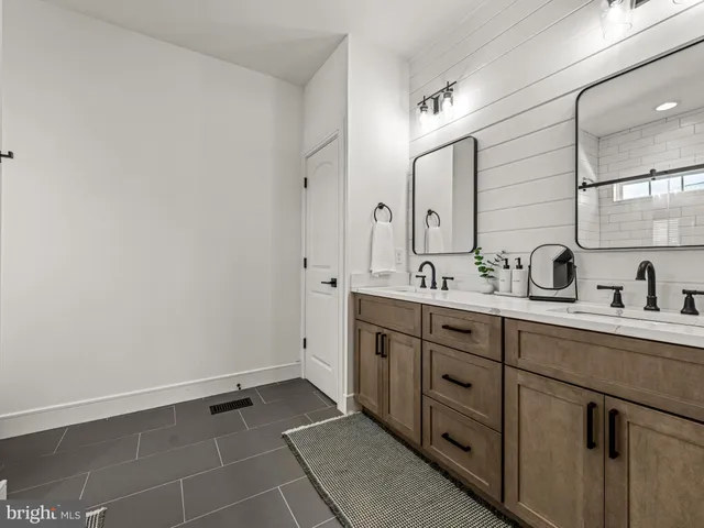 a spacious bathroom with a double vanity sink a mirror and with