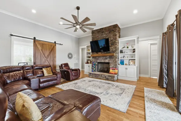 a living room with furniture a fireplace and a flat screen tv