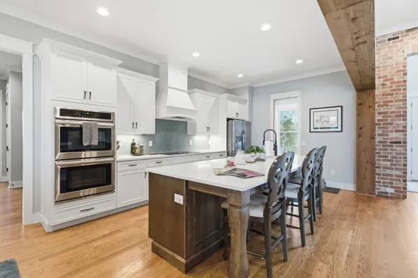 a kitchen with stainless steel appliances kitchen island granite countertop a stove a sink a microwave and a dining table