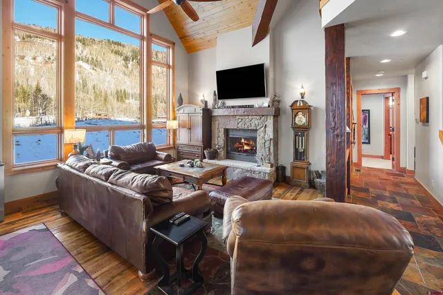 a living room with furniture a flat screen tv and a fireplace