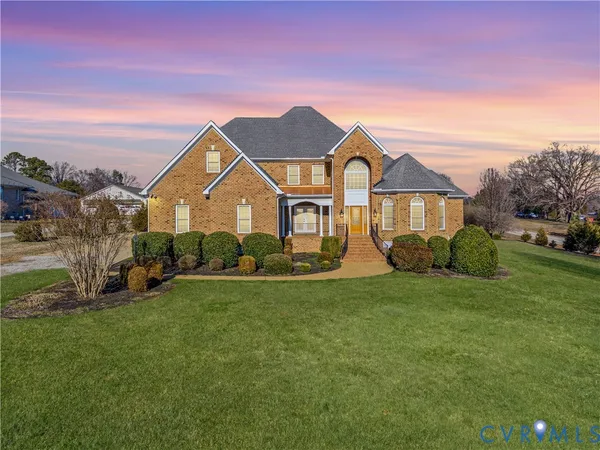 a view of a big house with a big yard and large trees