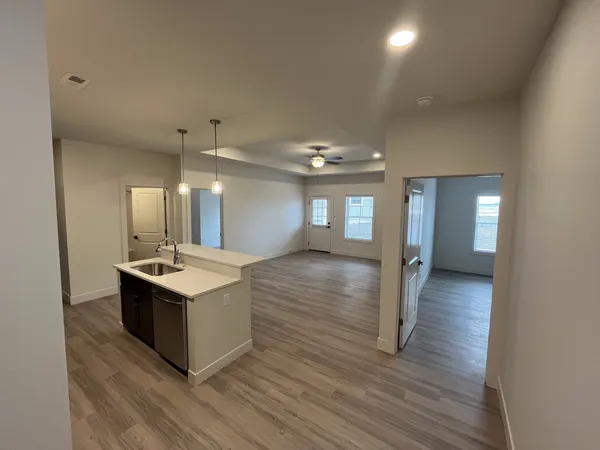 a kitchen with a sink and wooden floor