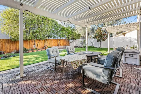 a view of a patio with table and chairs potted plants with wooden floor and fence