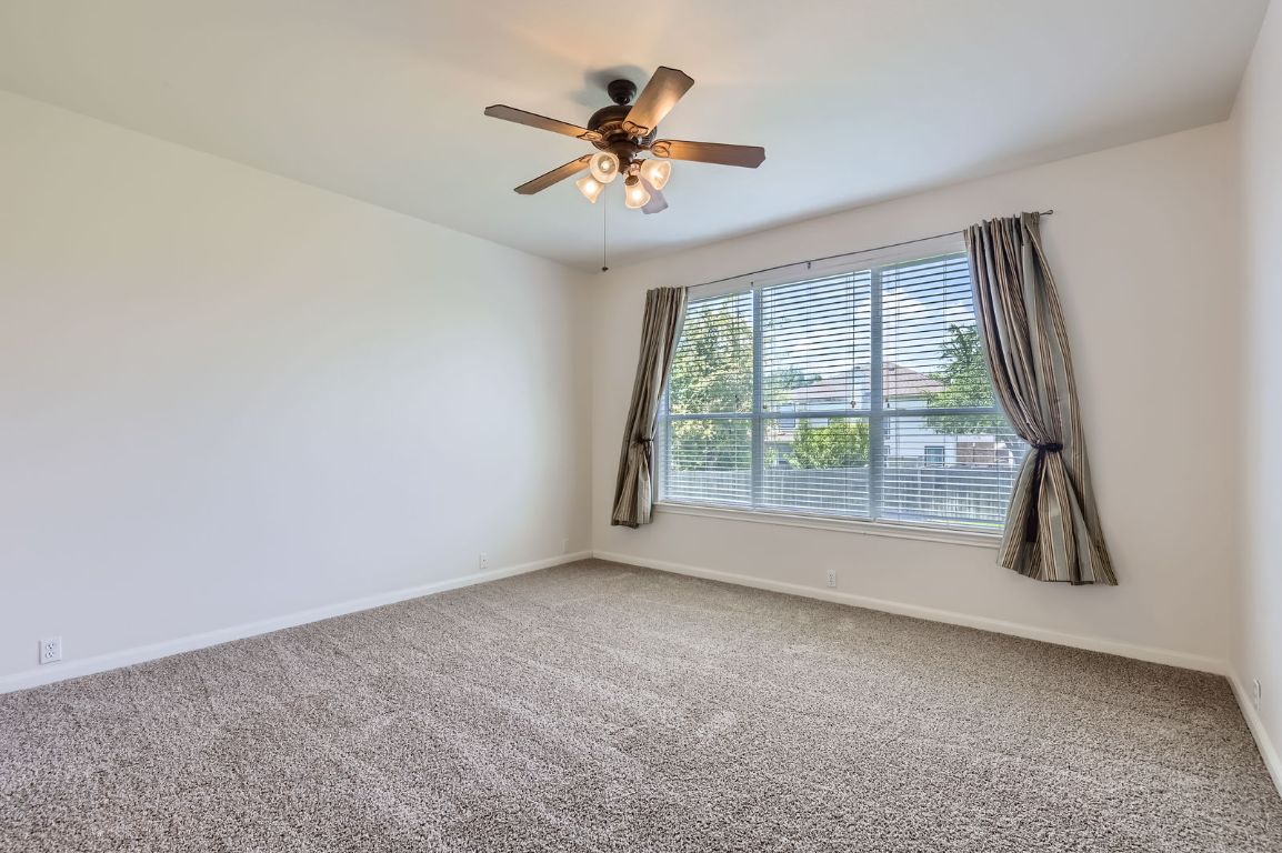 3423 Shiraz Loop Round Rock, TX 78665 - Photo 11 of 28 an empty room with windows and ceiling fan