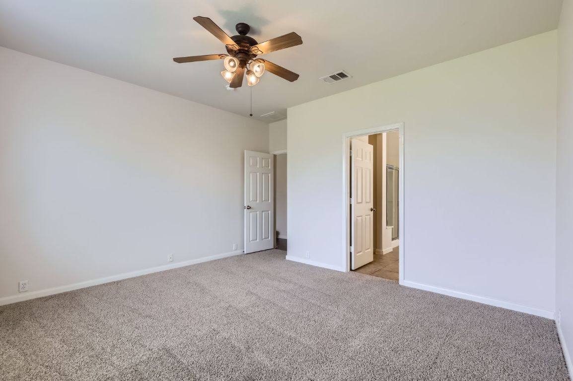 3423 Shiraz Loop Round Rock, TX 78665 - Photo 12 of 28 an empty room with a chandelier fan and windows