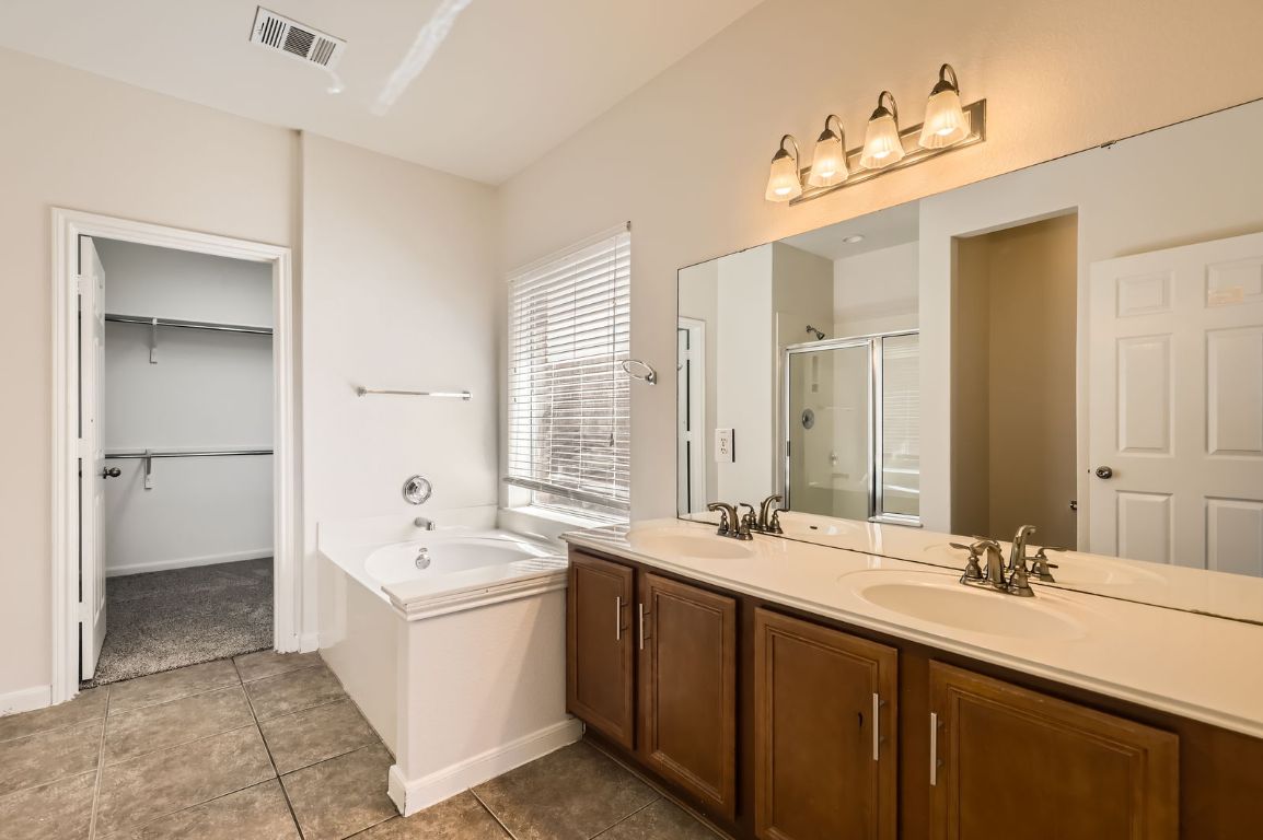 3423 Shiraz Loop Round Rock, TX 78665 - Photo 13 of 28 a bathroom with a double vanity sink mirror double and bathtub