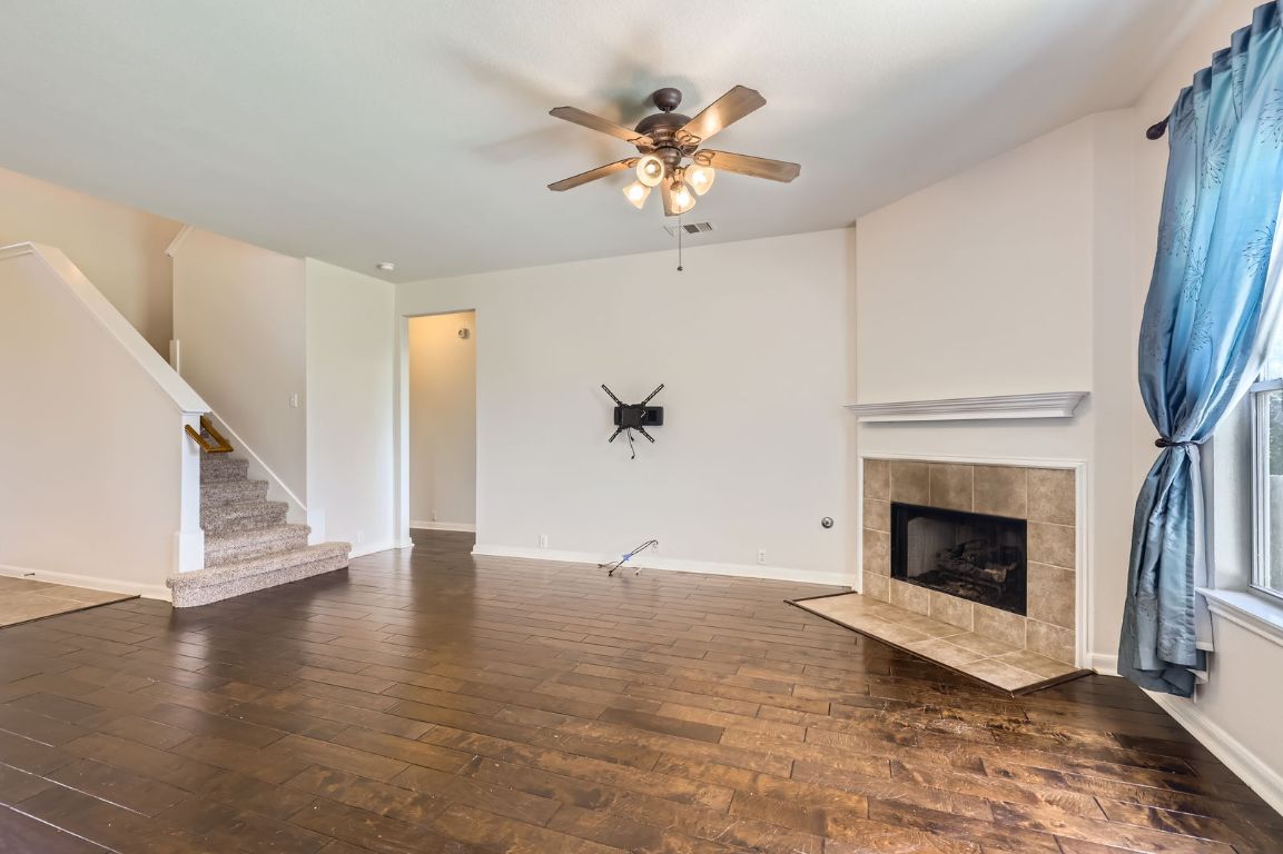 3423 Shiraz Loop Round Rock, TX 78665 - Photo 4 of 28 a view of an empty room with wooden floor and a fireplace