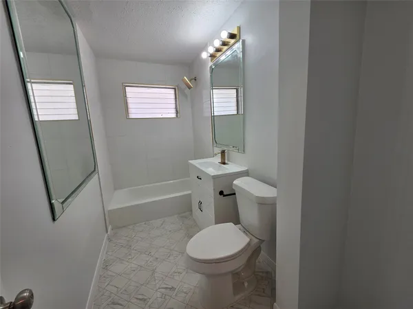 a bathroom with a toilet a sink and bathtub