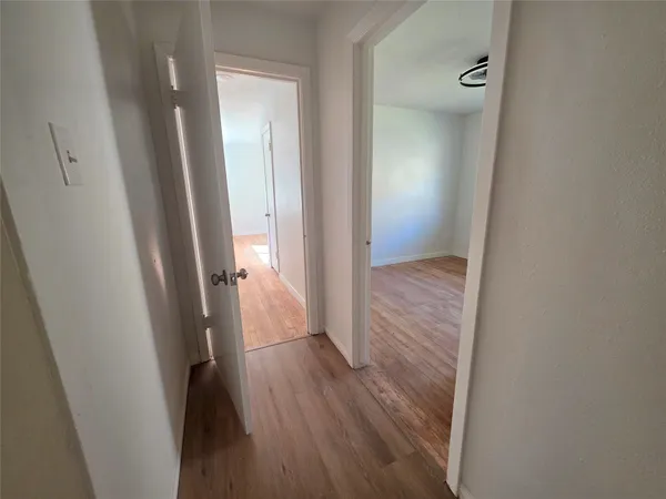 a view of a hallway with wooden floor