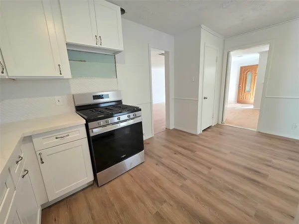 a kitchen with granite countertop white cabinets and white appliances