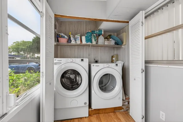 a view of a hallway with wooden floor and livingroom