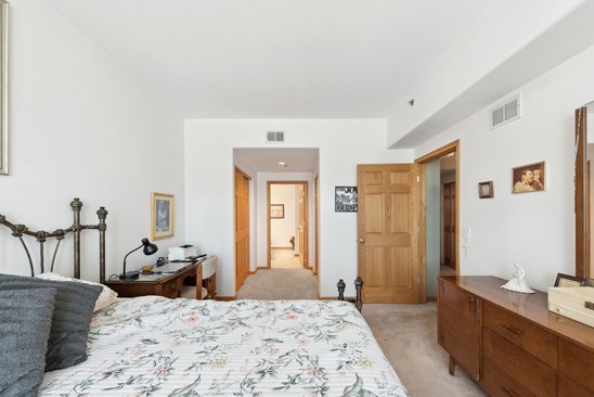 1705 Pavilion Way, Unit 504 Park Ridge, IL 60068 - Photo 12 of 15 a bedroom with a bed and wooden floor