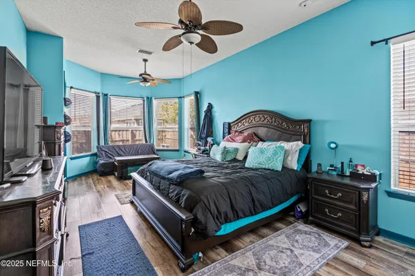 a bedroom with a bed and large windows