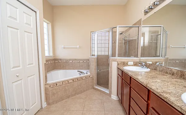 a bathroom with a granite countertop tub sink and mirror