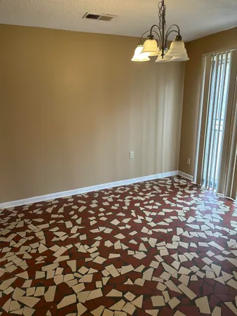 a view of a big room with windows and chandelier fan
