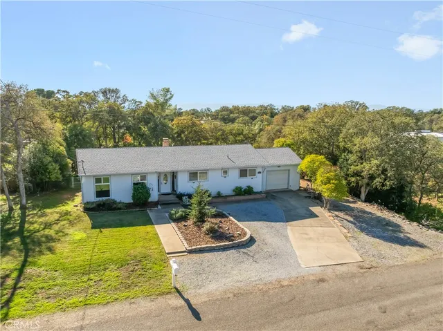 a view of a patio with couches under an umbrella next to yard