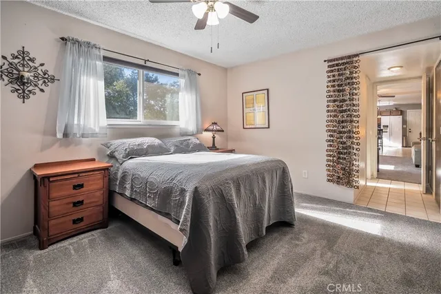 a bedroom with a bed and a chandelier fan