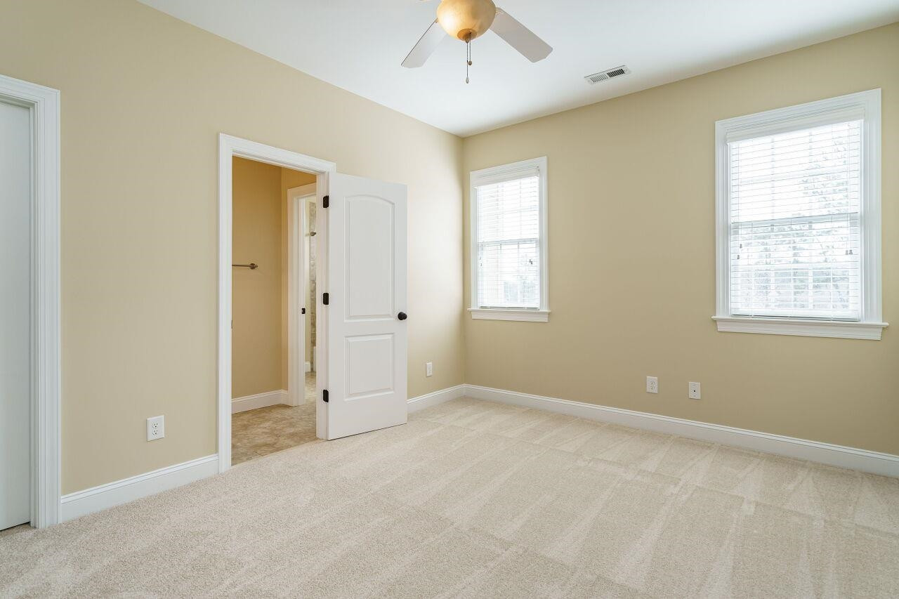 5327 Landguard Drive Raleigh, NC 27613 - Photo 27 of 45 New carpet, fan, neutral paint and closet with wooden shelving and cubbies. Upstairs bedroom