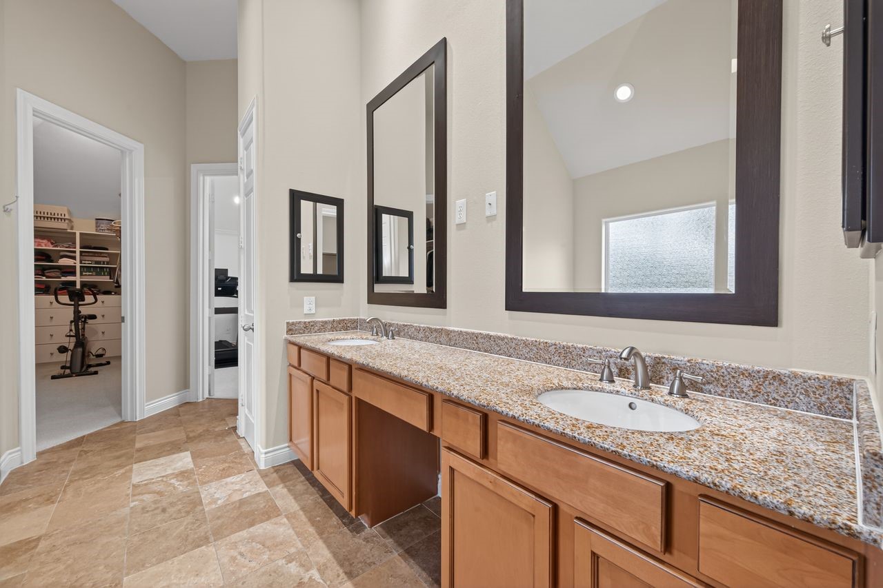 10932 Lasso Lane Houston, TX 77079 - Photo 17 of 38 a bathroom with a granite countertop double vanity sink and a mirror