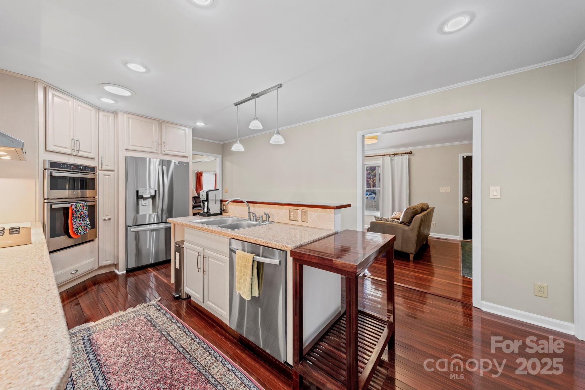 3400 Griffith Road Monroe, NC 28112 - Photo 32 of 46 a living room with stainless steel appliances furniture a rug and a kitchen view